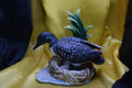 Ceramic wood duck sitting on a nest